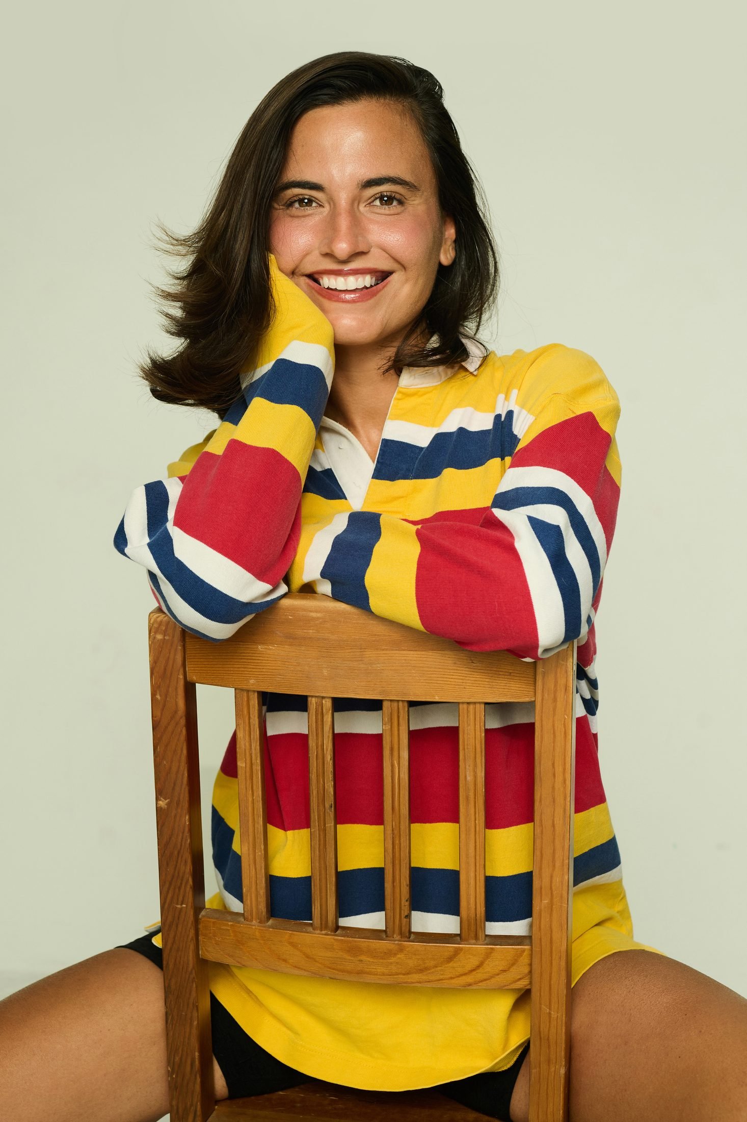 Actress and model headshot smiling warmly in vibrant colored vintage polo shirt