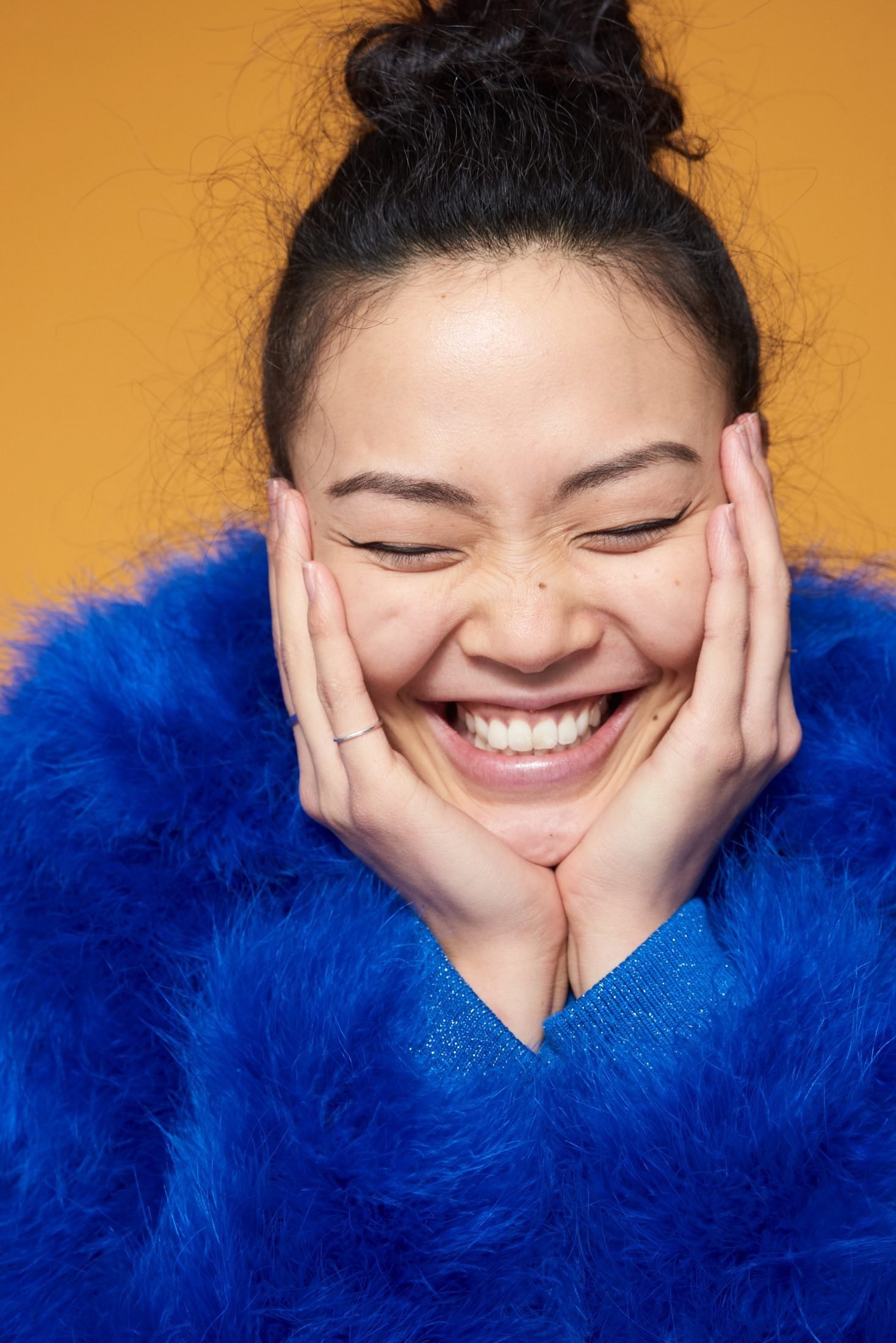 Candid portrait of a laughing woman in a bright blue sweater