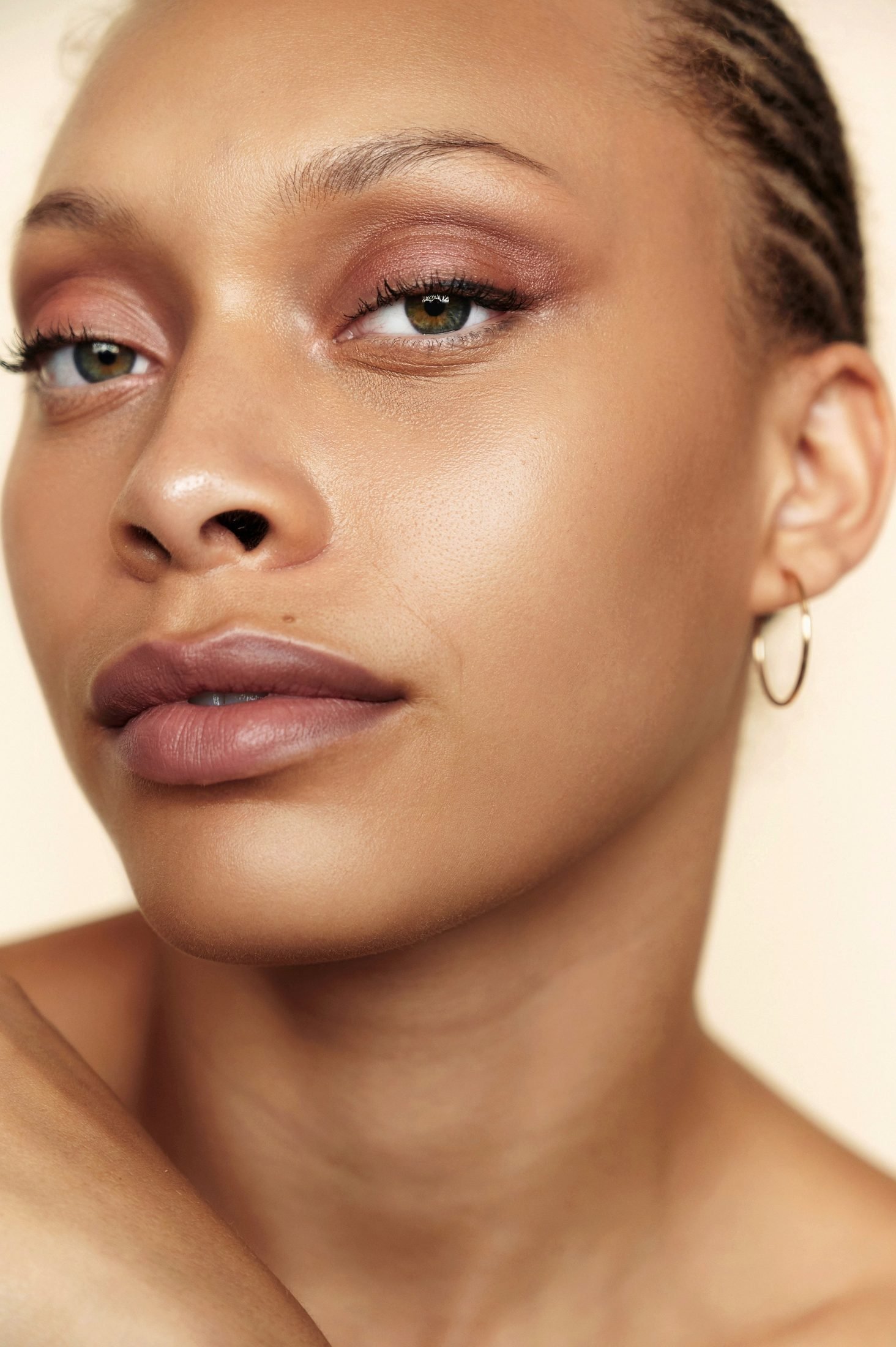 Beauty close-up of a woman with a gold hoop earring and braided hair