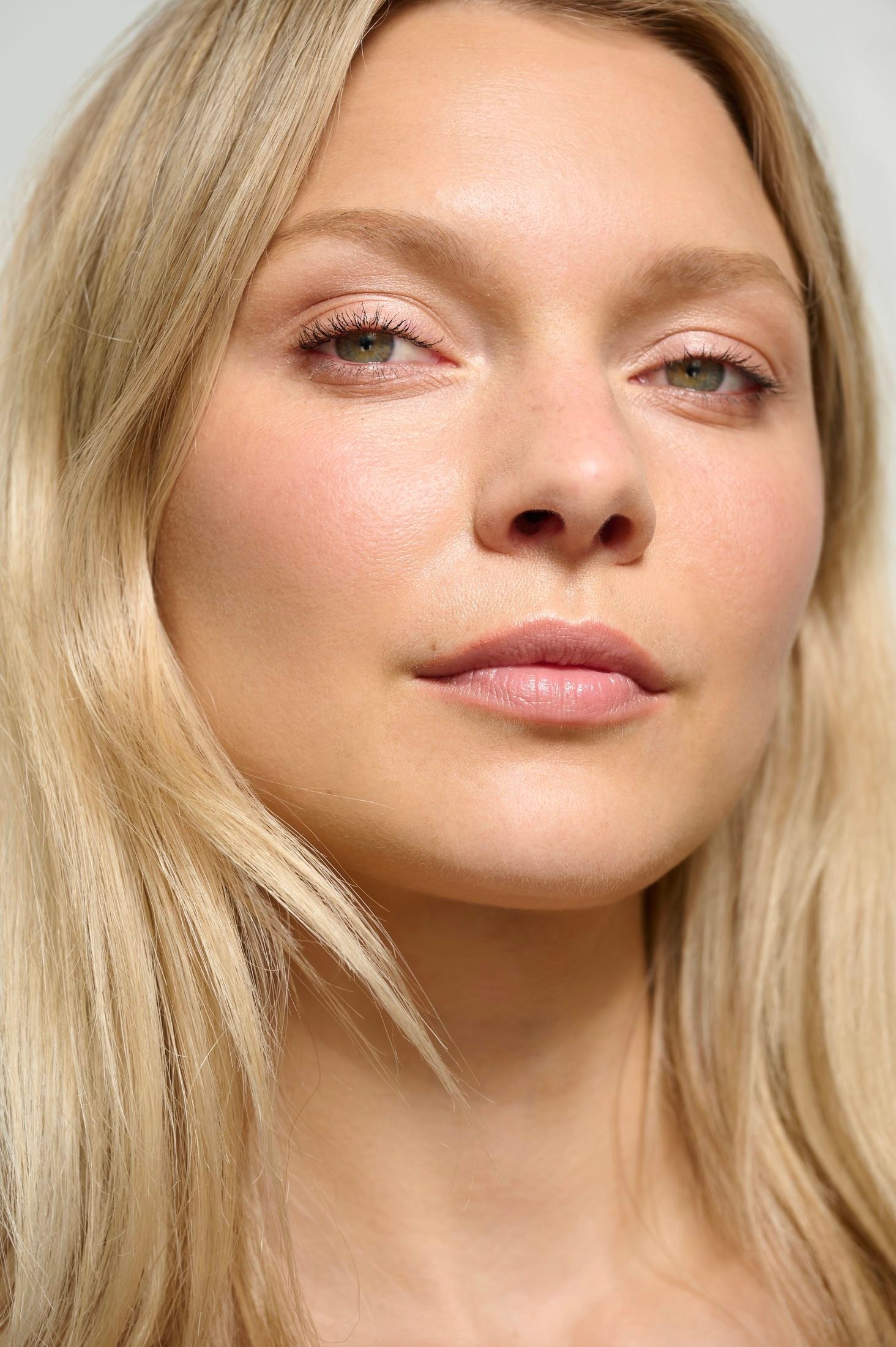 Close-up portrait of a blonde woman with subtle makeup