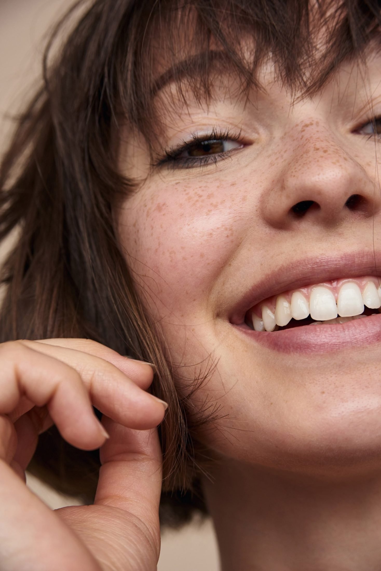 Candid beauty portrait of a smiling young woman with bangs